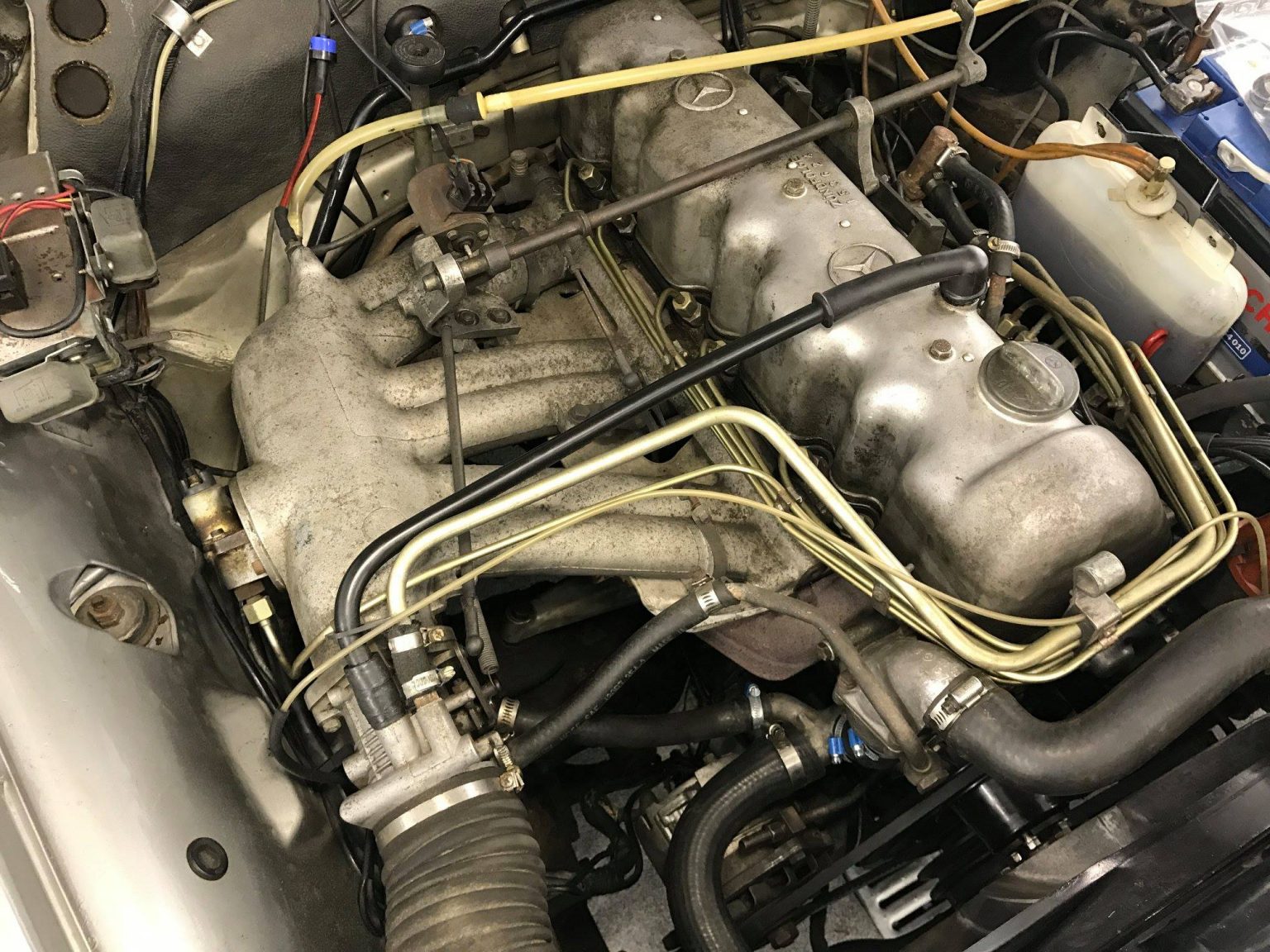 Older engine bay with corrosion before work